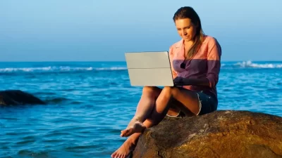 perempuan cewek main laptop di pinggir laut