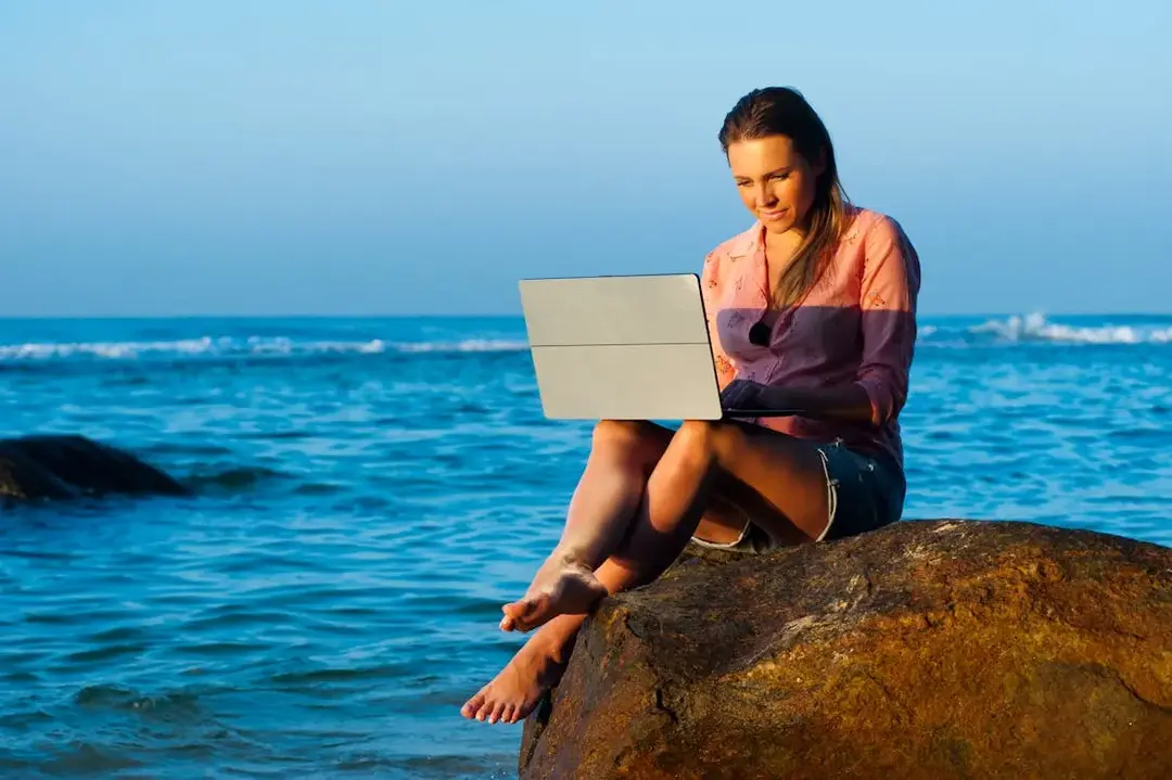 perempuan cewek main laptop di pinggir laut